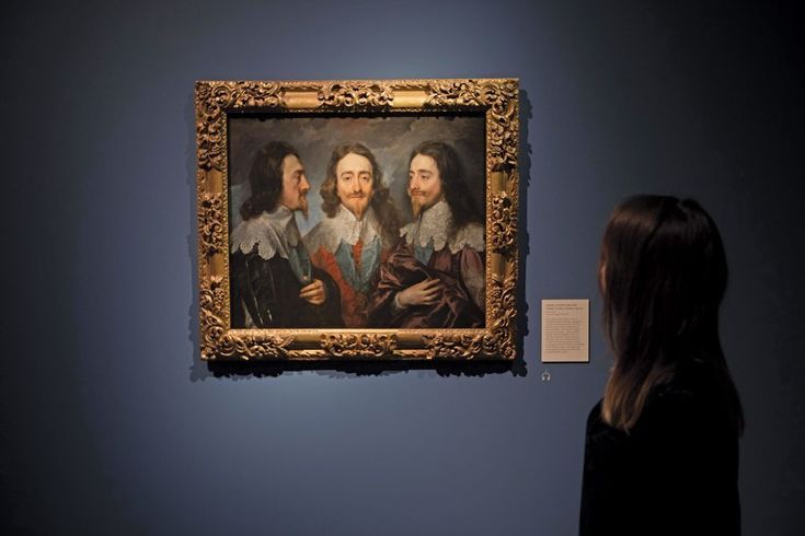 a woman looking at a painting on display