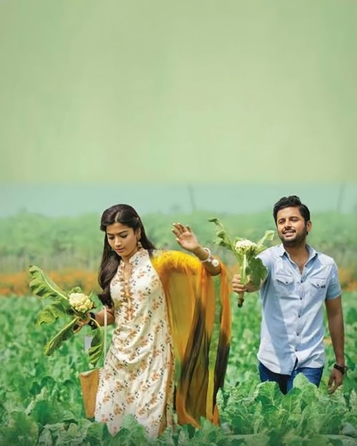 two people standing in a field holding flowers