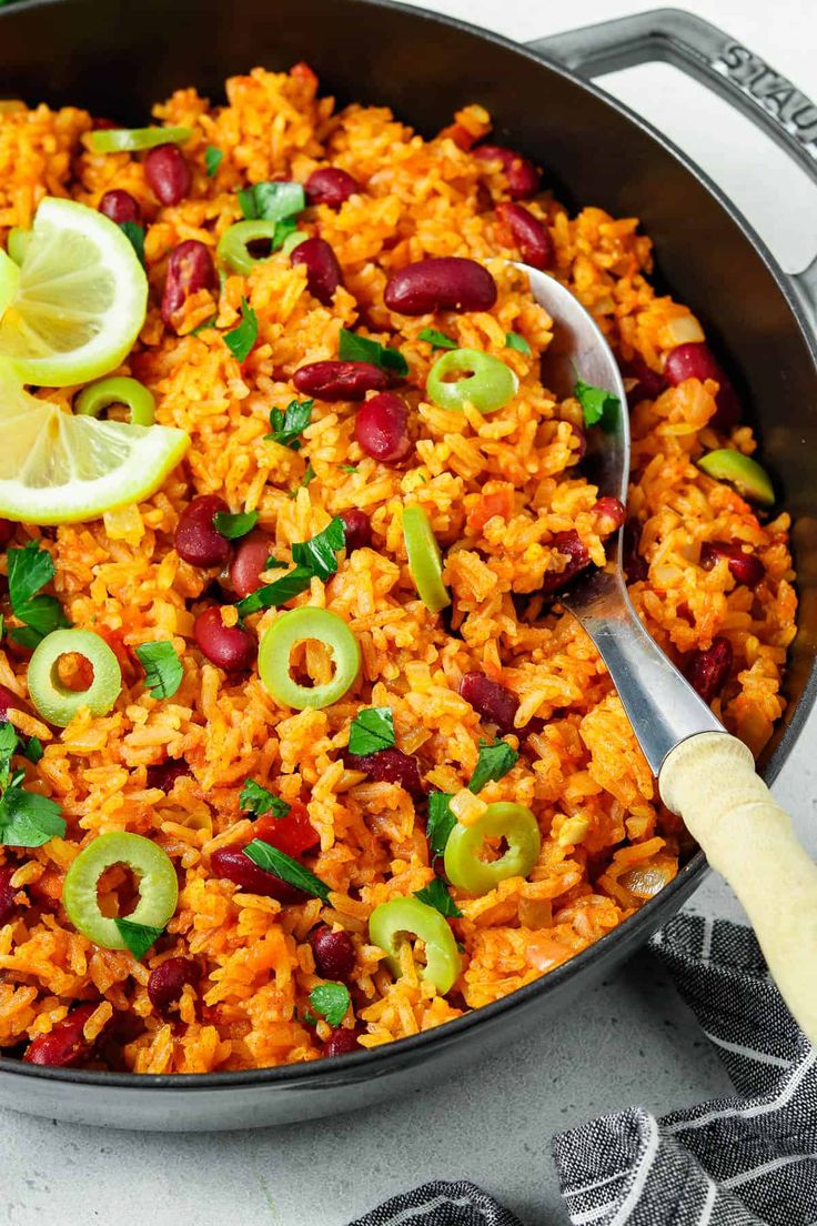 a pan filled with rice, beans and limes