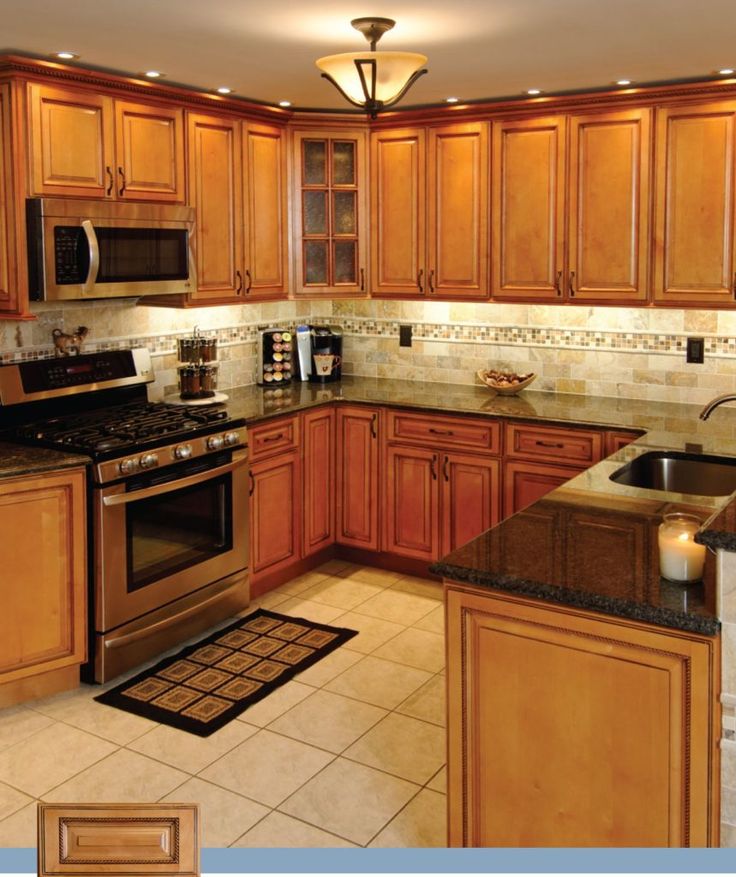 a kitchen with wooden cabinets and granite counter tops, stainless steel appliances and an oven