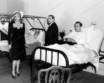 an old black and white photo of two people in a hospital bed with another man standing next to the bed