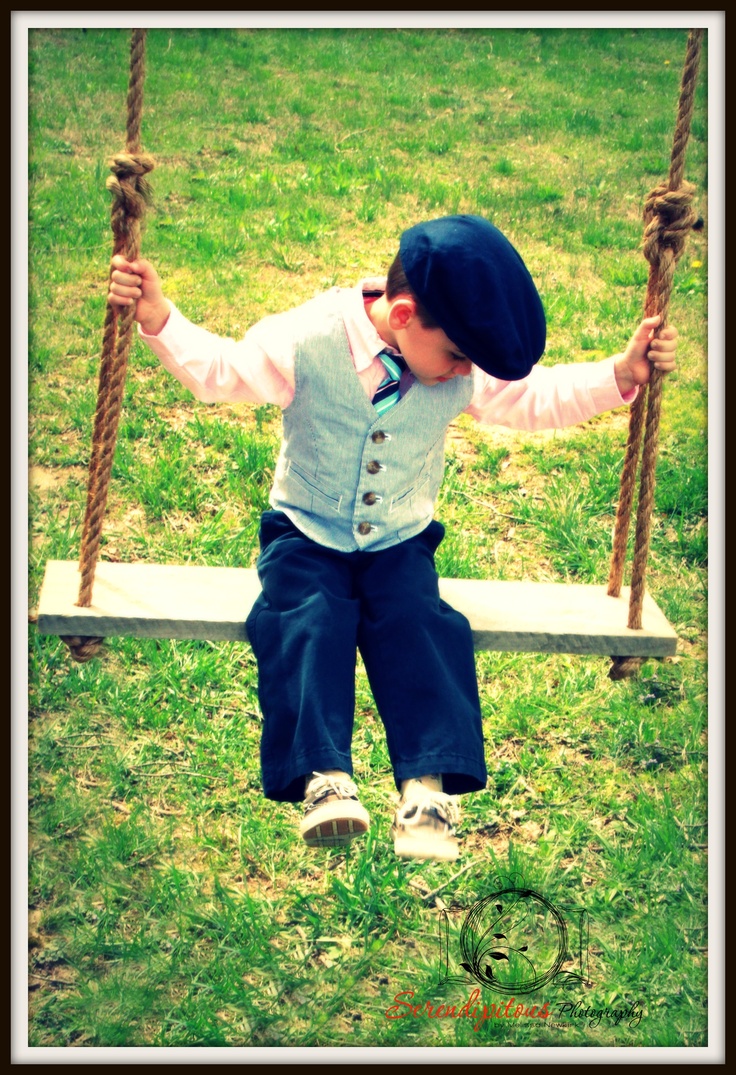 a young boy is sitting on a swing