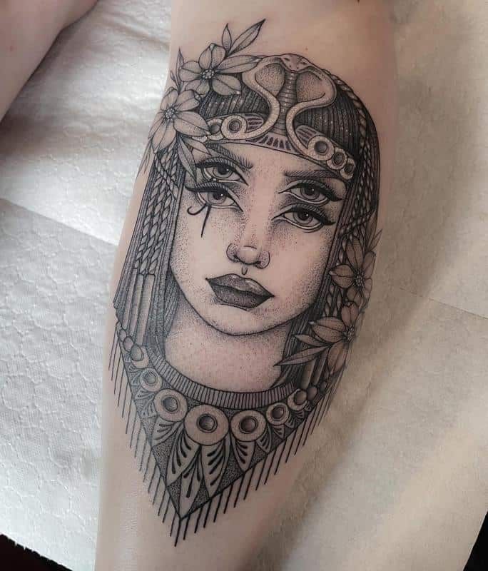 a woman's face with flowers and leaves on her head is shown in this tattoo design