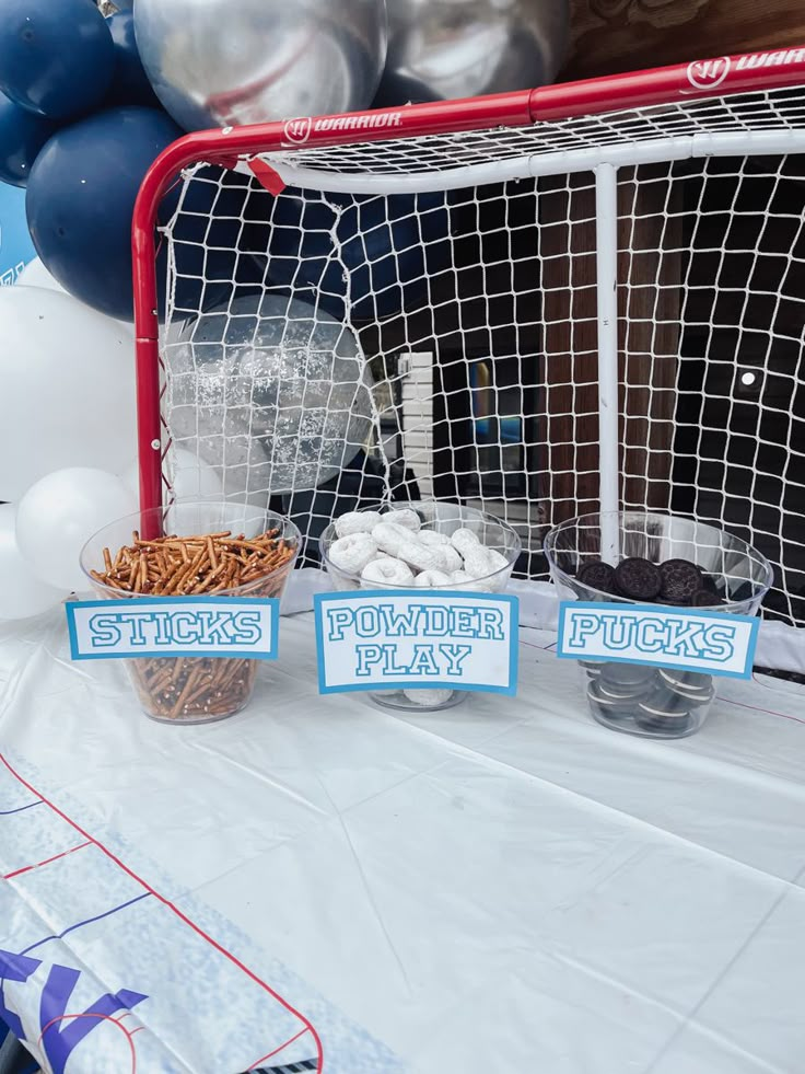 there is a hockey goal and other items on the table with balloons in the background