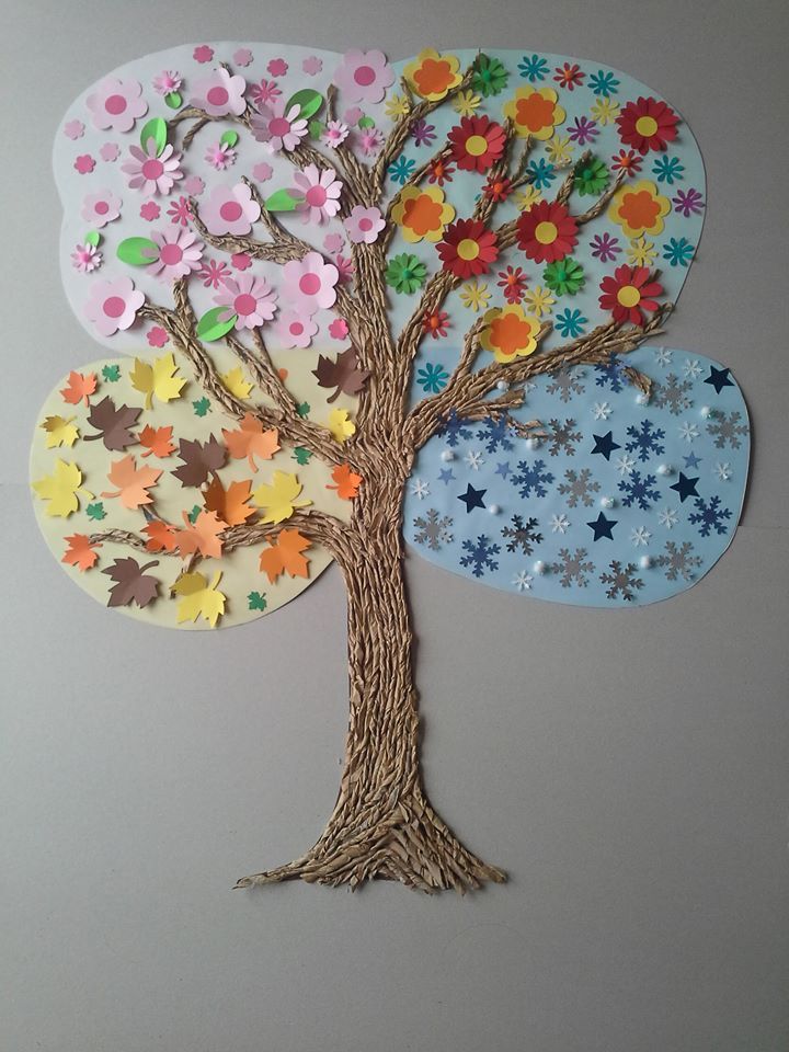 the paper tree is decorated with colorful flowers and leaves, as well as an ornament