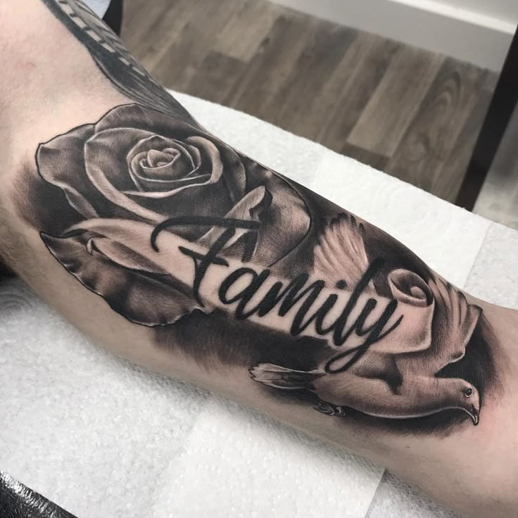 a man's arm with a rose and the word family tattooed on it in black ink