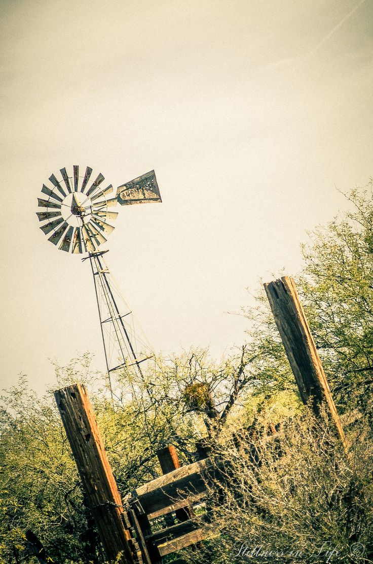 an old wooden fence with a windmill in the background