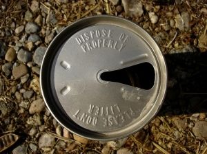 an empty metal can sitting on the ground