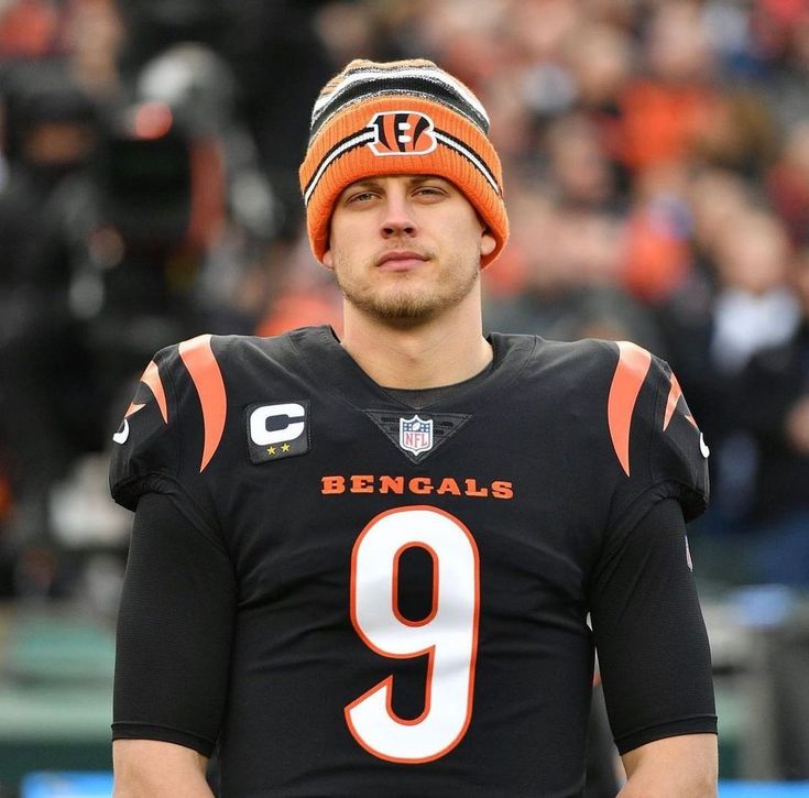 a football player wearing an orange and black hat with the number 9 written on it