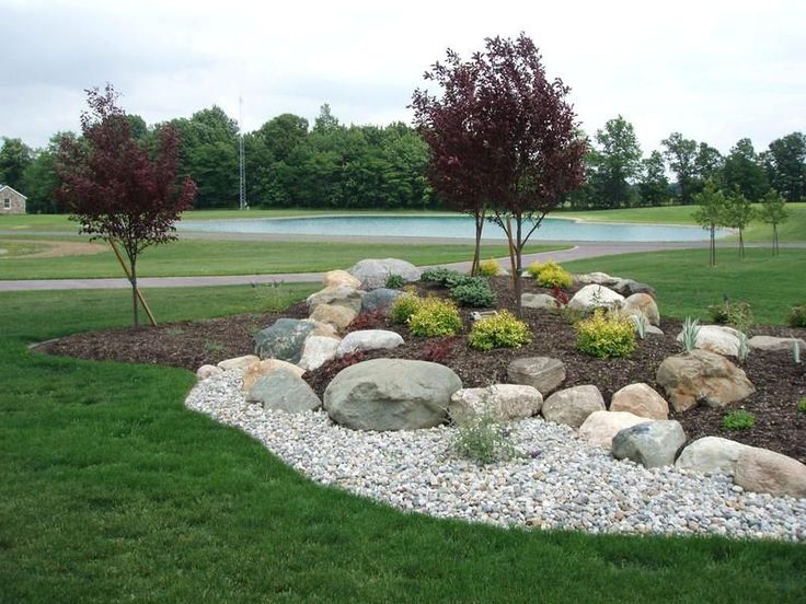 a rock garden in the middle of a grassy area