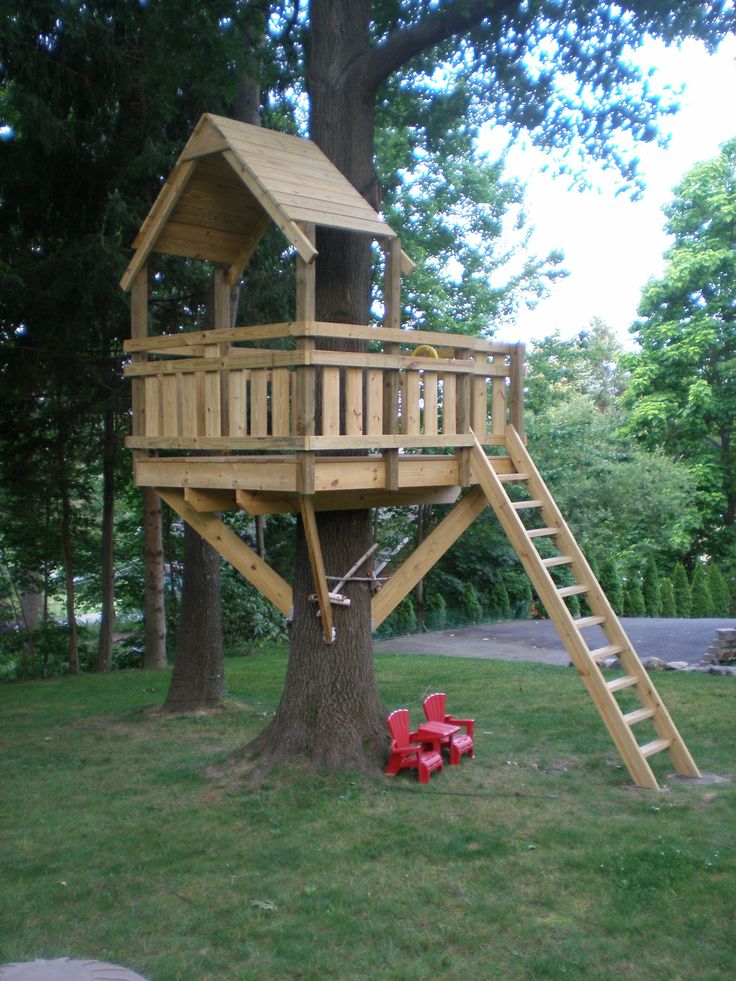 a tree house with a slide and fire hydrant