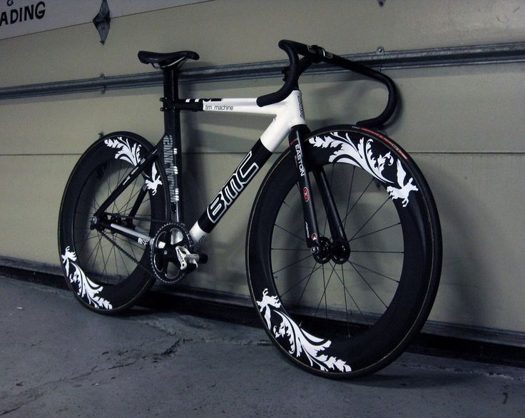 the bike is leaning against the wall in front of the garage door and it's black and white paint