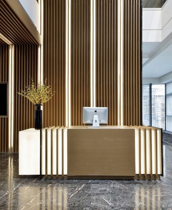 an office with marble flooring and wooden partitions on the walls, along with a computer desk