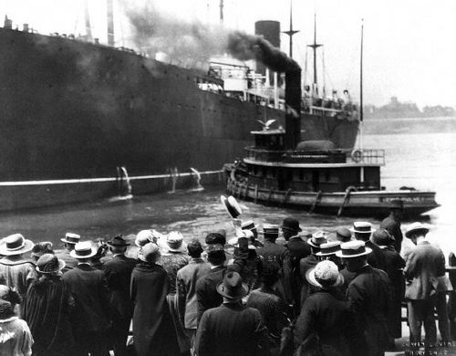 a group of people standing in front of a large ship