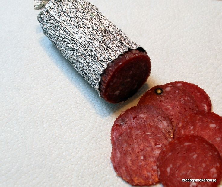 two pieces of meat sitting next to each other on a white tablecloth covered surface