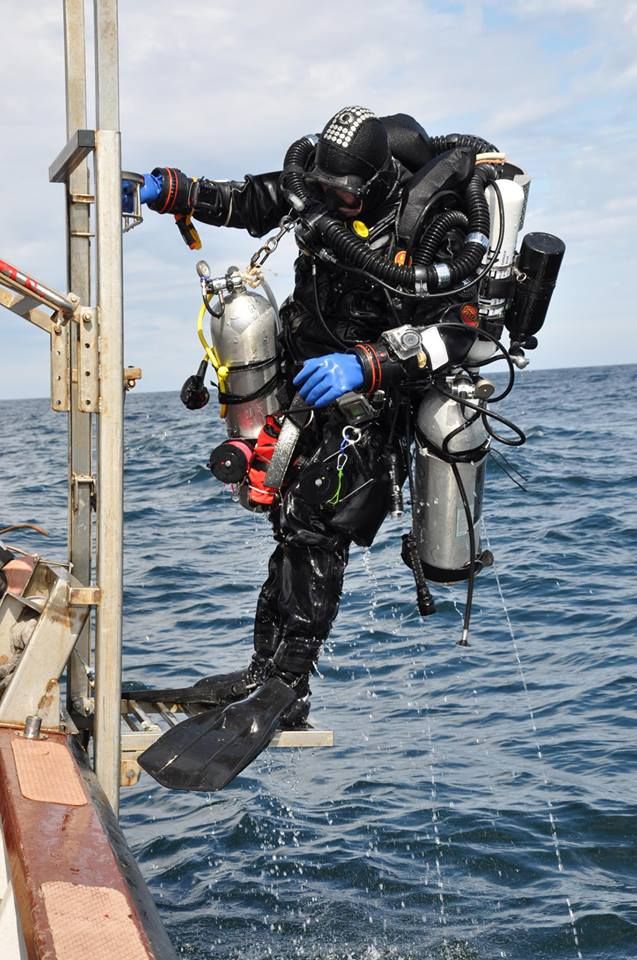 a man in diving gear is on the side of a boat