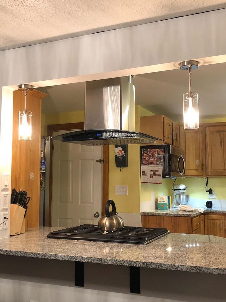 a kitchen with a stove top oven sitting inside of it's reflection in the mirror