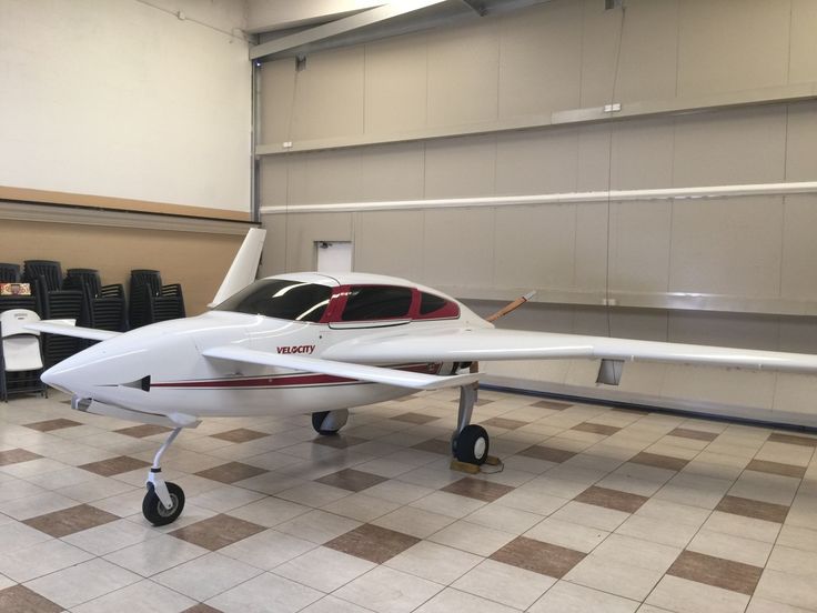 a small white airplane sitting on top of a tiled floor