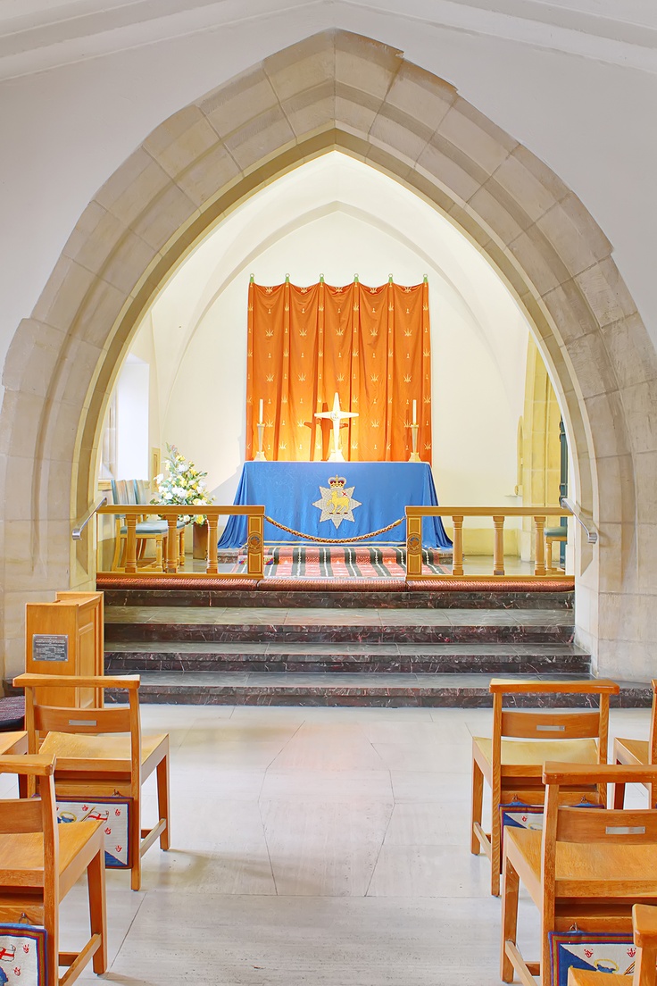 the interior of a church with wooden pews and blue cloth draped over the alter