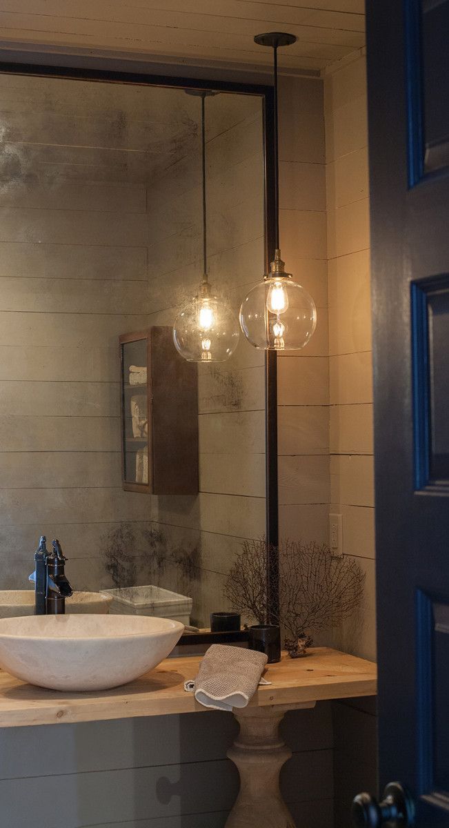 a bathroom sink sitting under a large mirror next to a light on top of a counter