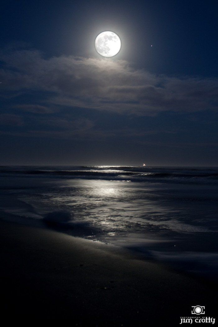 the full moon shines brightly over the ocean