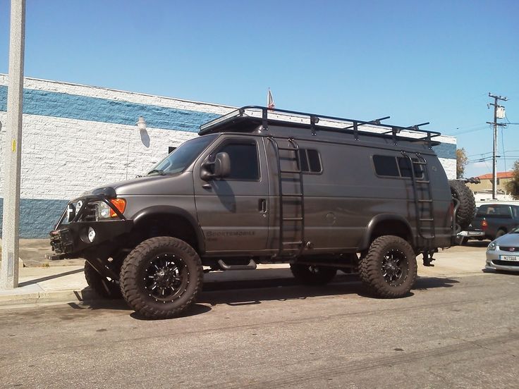 an suv parked in front of a building with a roof rack on it's flatbed