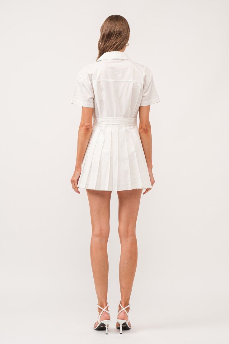 The White Romper Dress is a versatile addition to any wardrobe. Made from 100% cotton, this dress features a stylish wrap design, a pleated skirt, and a classic collar. With its mini length, it is perfect for both casual and formal occasions. Stay comfortable and chic in this must-have dress. collared wrap style romper dress (shorts built in) hand wash cold / line dry model is 5'11" and is wearing a size small Fitted Cotton Mini Dress With Pleats, Short Sleeve Mini Dress With Pleated Hem For Summer, Summer Mini Dress With Pleated Hem And Short Sleeves, Cotton Dresses With Pleated Waist For Day Out, Pleated Cotton Mini Dress For Daywear, Cotton Pleated Mini Dress For Daywear, Elegant Pleated Cotton Mini Dress, Summer Shirt Dress With Pleated Hem For Daywear, Summer Pleated Hem Shirt Dress For Daywear