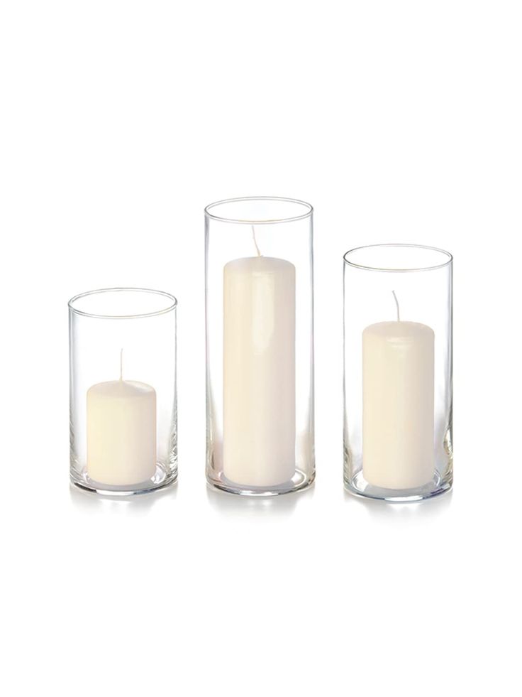 three clear glass candles are sitting in front of each other