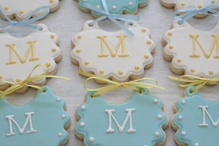 decorated cookies with blue and white icing are arranged on a tableclothed surface