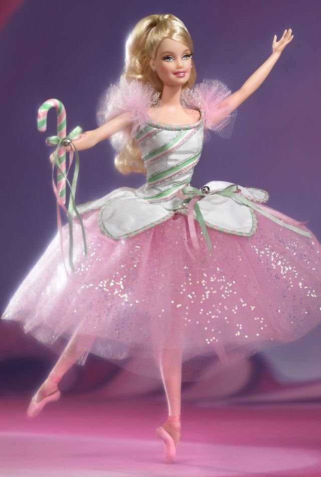 a barbie doll is dressed in pink and white with a candy cane on her hand