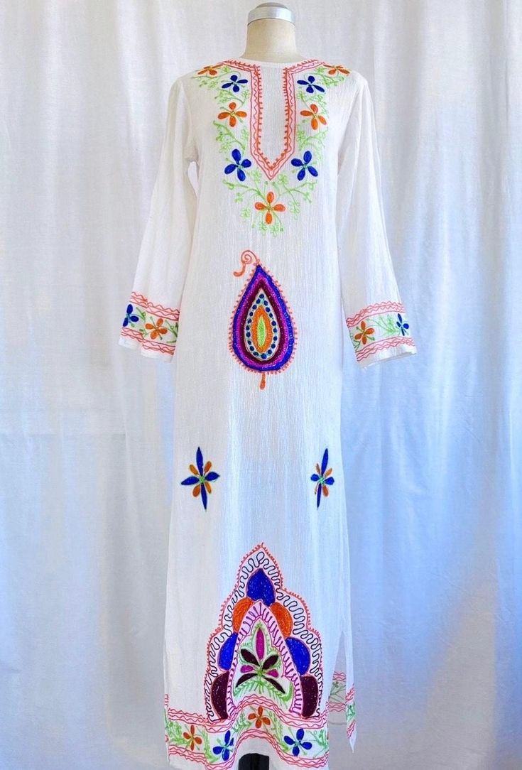 Amazing original 70s vintage Indian embroidered cotton kaftan, in great slim fit. FEATURES > Indian white cotton kaftan, embroidered with ethnic pattern in colours of royal blue, tangerine, lime, hot pink and burgundy > Maxi length style >  3/4 slightly flared sleeves  > Centre back neck opening > 100% cotton  > Size small (please check the measurements) > Good vintage condition, with a couple of small marks MEASUREMENTS (all measurements taken laying flat) > shoulder: 14" or 35cm > bust: 17" or 43cm > sleeve length from shoulder: 20 1/2" or 51.5cm > waist: 16 1/2" or 41.5cm > hips : 17 1/2" or 44cm > total length: 49 1/2" or 125cm PLEASE NOTE > All items are shipped with by standard international post with tracking but if you would prefer a cheaper shipping option, combined shipping or ad Long Multicolor Embroidered Kaftan For Festive Occasions, Long Kaftan With Multicolor Embroidery For Festive Occasions, Long Festive Kaftan With Multicolor Embroidery, Festive Long Kaftan With Multicolor Embroidery, White Folk Style Kaftan For Vacation, White Chikankari Embroidery Kaftan For Vacation, White Long Kaftan For Festival, Spring Festival Kaftan With Chikankari Embroidery, Long Multicolor Kaftan With Resham Embroidery