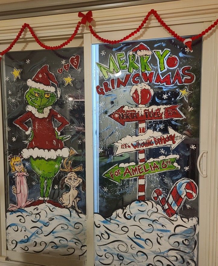 two decorated glass doors with christmas signs on them