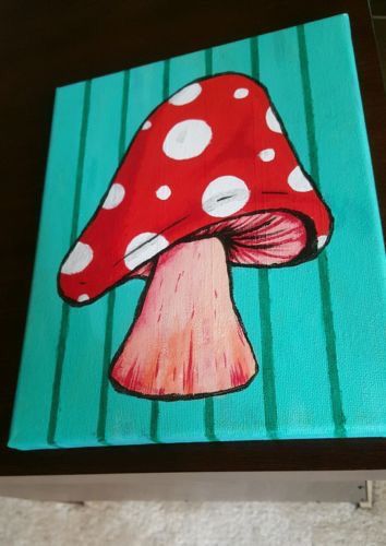 a painting of a red mushroom on a green striped tablecloth with white polka dots