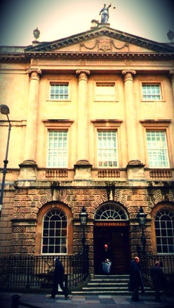 an old building with people walking in front