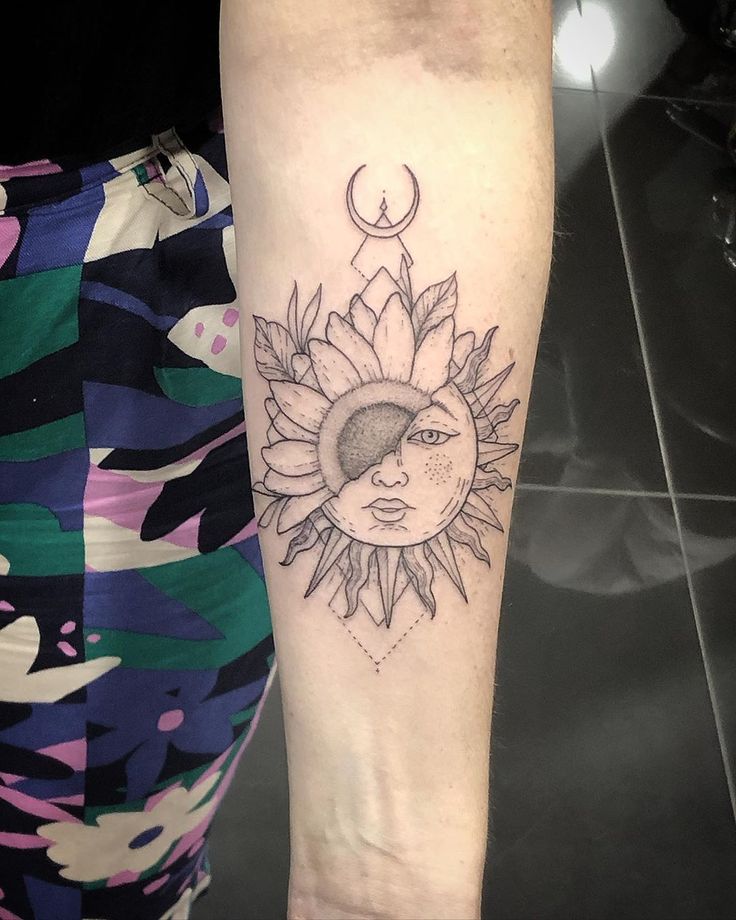 a woman's arm with a sunflower and moon tattoo on the left forearm