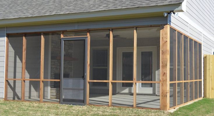 a screened in porch with sliding glass doors on the front and back side of it