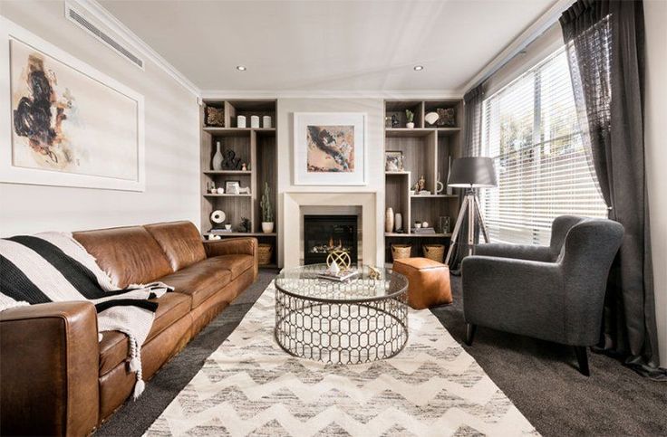 a living room filled with furniture and a fire place next to a bookcase full of books