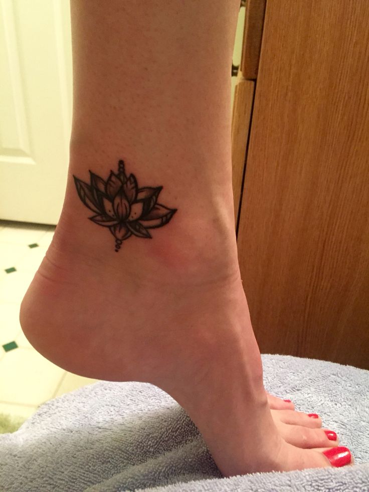 a woman's foot with a small lotus tattoo on the side of her leg