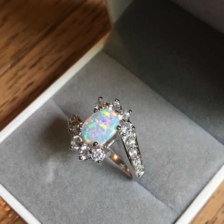 an opal and diamond ring in a box