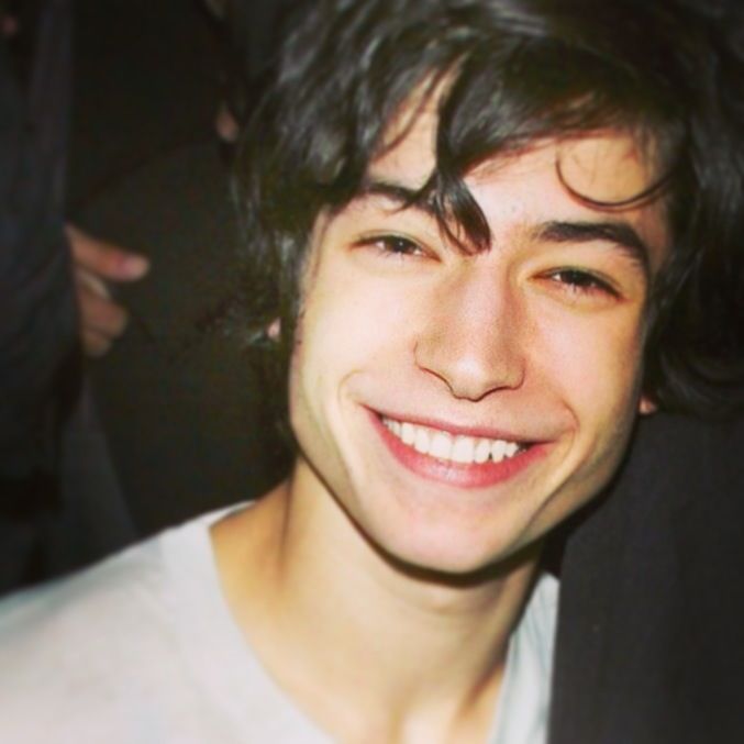 a smiling young man sitting at a table