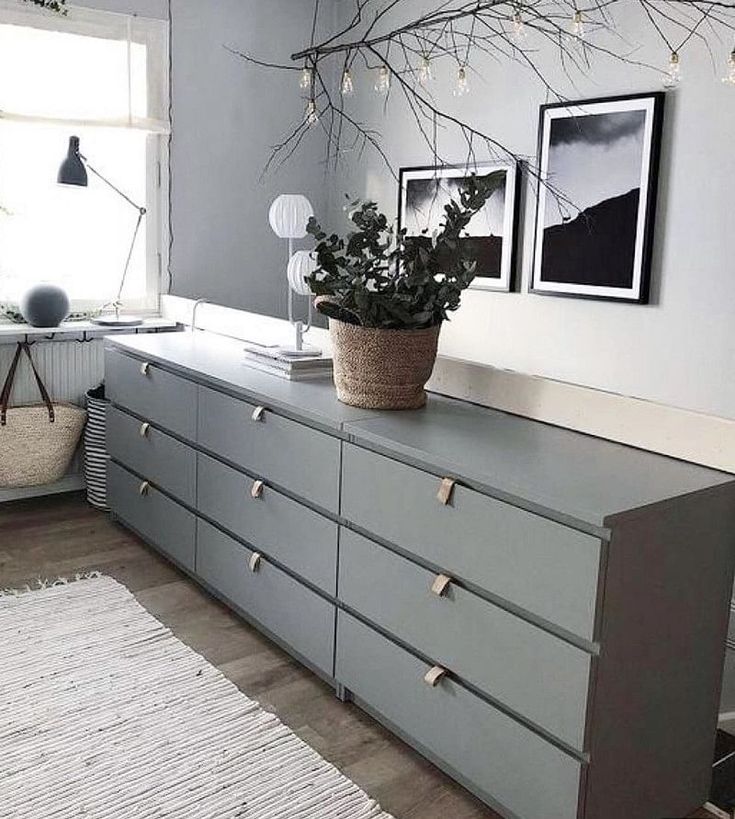 a room that has some plants on top of the dressers and rug in front of it