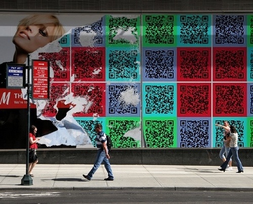 people walking down the sidewalk in front of a building with qr code on it