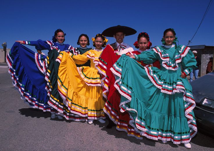 a group of women in colorful dresses standing next to each other