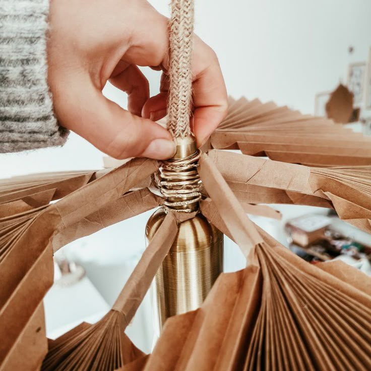 a person that is working on some kind of thing out of paper and wood sticks