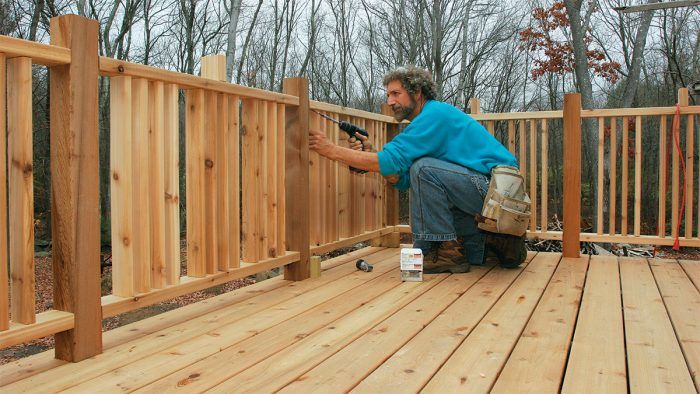 a man working on a wooden deck in the woods