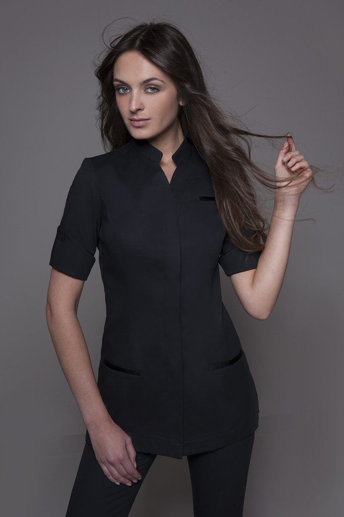 NIAGARA Tunic in Black: Hospitality & Spa Uniforms  �   Exquisite Versatility! Elegant and comfortable spa tunic with an invisible button front closure hidden under lapel. The mid-length cuffed sleeves, embellished by two lateral buttons for a "Couture" touch, can be worn up or down for two different styles. The side slit on the sleeves allows them to be worn un-cuffed without losing comfort.  Three pockets, enhanced with discreet satin, make this top the ultimate embodime... Beauty Therapist Uniform, Dental Uniforms, Salon Uniform, Beauty Uniforms, Spa Uniform, Hotel Uniform, Scrubs Outfit, Hospitality Uniform, Medical Uniforms