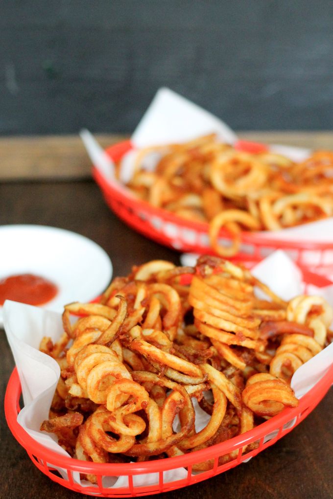 two baskets filled with onion rings on top of a table