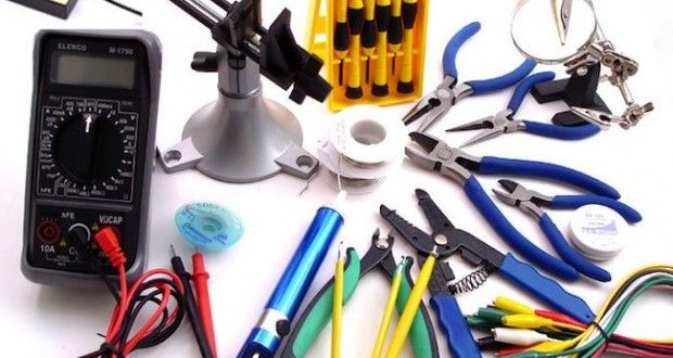 many different tools are laid out on a table with wires and other electrical equipment around them