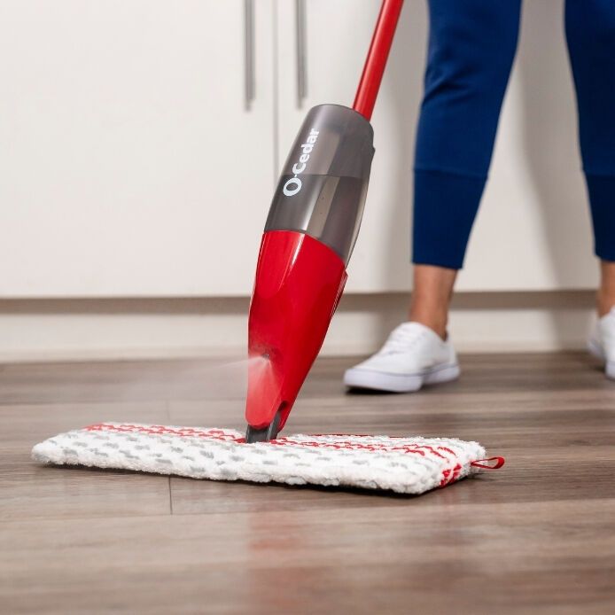 a woman is cleaning the floor with a red vacuum mop and microfibre