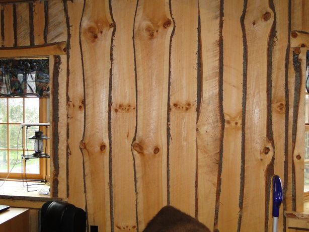 there is a wood paneled wall in the room with many pieces of wood on it